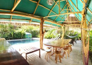 a patio with a table and chairs and a pool at Aloha Surf Nosara - Casa 'Ohana in Nosara