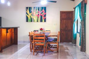 a dining room with a wooden table and chairs at Aloha Surf Nosara - Casa 'Ohana in Nosara
