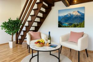a living room with a table and chairs and a mountain at STAYS Bodensee Apartments in Stetten +8 photos