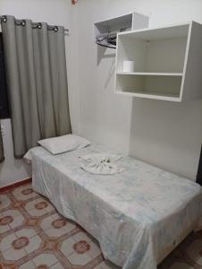 ein Schlafzimmer mit einem Bett mit einem Spiegel und einem Vorhang in der Unterkunft Hotel Pousada Central Campo Grande in Campo Grande + 17 Fotos