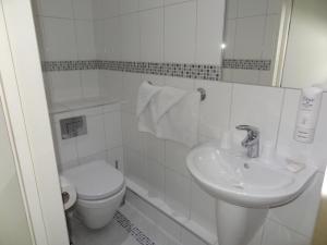een witte badkamer met een toilet en een wastafel bij Hotel Unique in Londen