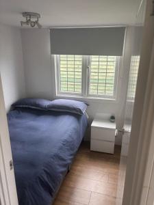 Un dormitorio con una cama azul y una ventana. en Shannon - 113, en Leysdown-on-Sea