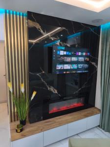 TV de pantalla plana en la parte superior de una pared en Blu Apartments, en Jugów