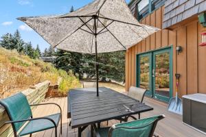 a wooden table with an umbrella on a deck at Scenic Basecamp Retreat Near Trails and Town in Vail