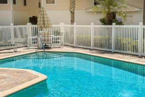 een zwembad voor een wit hek bij Seashell 20 in Clearwater Beach