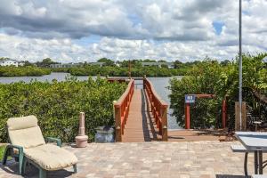 een houten steiger met een tafel en een stoel en een rivier bij Seashell 20 in Clearwater Beach