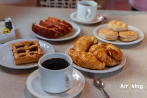 a table with plates of pastries and a cup of coffee at Hotel Boutique con Desayuno in Tafí del Valle