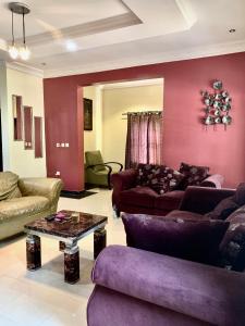 a living room with purple furniture and a table at 1BR Home in Shelter Afrique in Uyo