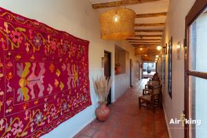 a hallway with a red painting on the wall at Hotel Boutique con Desayuno in Tafí del Valle