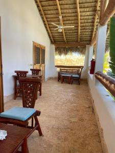 a room with tables and chairs and a ceiling at Guest-Room 2 Palmeras with a pool in Las Galeras in Las Galeras