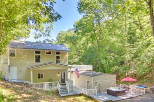 a yellow house with a porch and an american flag at Close to Snowtubing! Hot Tub Hideaway in Lake Lure in Lake Lure