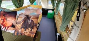 a small bedroom with a bed with a horse blanket at Pipowagen bij Sneek, voor maximaal 2 personen in Hommerts