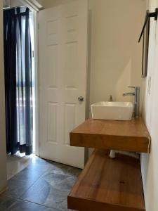 a bathroom with a sink and a white door at Casa De La Palmera in Brisas de Zicatela +64 photos