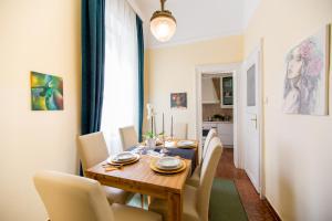 a dining room with a wooden table and white chairs at Elegant & Stylish Apartment city center in Budapest