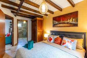 a bedroom with a bed and a painting on the wall at Casita Surfside in Noord