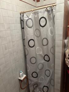 a shower curtain in a bathroom with a toilet at Il Riccio - Camera rosa in Isola Rossa
