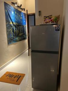 Un refrigerador en una habitación con un cuadro en la pared. en The Vaulted Retreat! F7, en Islamabad