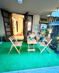 2 sillas y una mesa sobre una alfombra verde en The Vaulted Retreat! F7, en Islamabad