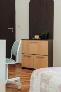 ein Schlafzimmer mit einer Holzkommode und einem Stuhl in der Unterkunft 55 Perla Collective in Nessebar