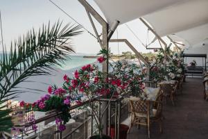 ein Restaurant mit Tischen und Stühlen mit Blumen in der Unterkunft 55 Perla Collective in Nessebar