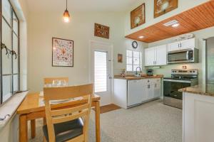 a kitchen with white cabinets and a wooden table at 3 Mi to Dtwn Fort Myers Apt with Outdoor Space in Fort Myers