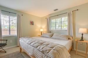 a bedroom with a bed and two windows at 3 Mi to Dtwn Fort Myers Apt with Outdoor Space in Fort Myers