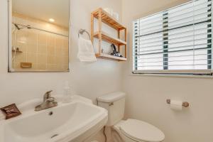 a white bathroom with a toilet and a sink at 3 Mi to Dtwn Fort Myers Apt with Outdoor Space in Fort Myers +17 photos