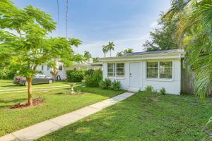 a white house with a tree in a yard at 3 Mi to Dtwn Fort Myers Apt with Outdoor Space in Fort Myers