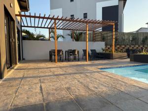 a patio with a table and chairs next to a pool at Charming 2 Bedroom apartment in Ballito