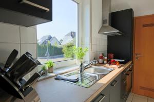 a kitchen with a sink and a window at Ferienwohnungen Möhnesee - zentral, stilvoll und ruhig mit Balkon und Boxspringbetten in Möhnesee