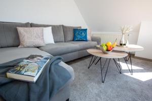 sala de estar con sofá y mesa con libro en Ferienwohnung Möhnesee - zentral, stilvoll und ruhig mit Balkon und Boxspringbetten, en Möhnesee