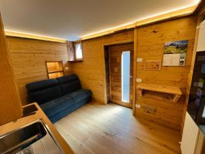 a living room with a blue couch in a room at Baita Snow Valtellina in Chiesa in Valmalenco