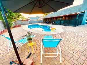 a patio with an umbrella and chairs and a pool at Phoenix Home - Oasis by the Hills in Phoenix
