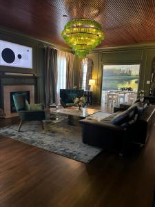 a living room with a couch and a chandelier at Swiss Avenue Luxury 1br Condo Historic Dallas in Dallas