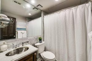 un baño con inodoro y lavabo en Elegant 1br Retreat On Dallas Swiss Avenue, en Dallas