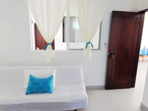 a white couch with a blue pillow in a room at Owl House in Puerto Ayora