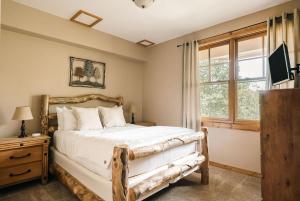シルバーソーンにあるSki Hike Relax - Log Cabin with Views - Hot tubのベッドと窓のある寝室