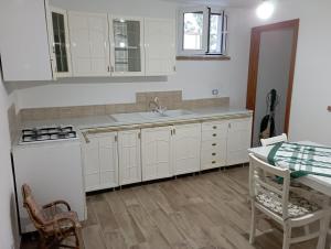 a kitchen with white cabinets and a sink and a table at Casa vacanza luisa in Sezze