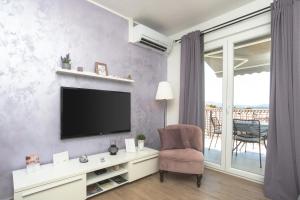 a living room with a television and a chair at Dalma Residence apartman Lavandella in Zaboric