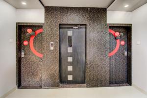 a row of elevators with red decorations on a wall at Collection O Rajdhani Hotel in Pune