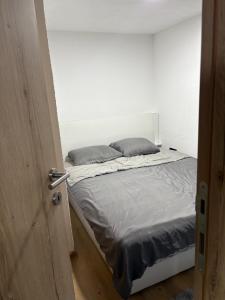 a bed in a room with a white wall at Lux Escape Pridolci in Kozica