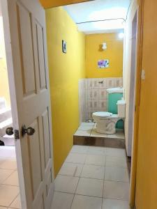 a bathroom with a toilet in a yellow room at Hotel los angeles sjp in San José Pinula