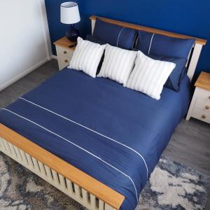 a bed with blue sheets and white pillows on it at Reverie Escape by Halisi in Ramsgate