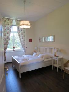 Un dormitorio con una gran cama blanca y una ventana en Schloss Lohm, en Lohm