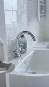 a kitchen sink with a faucet on top of it at Reverie Escape by Halisi in Ramsgate +43 photos