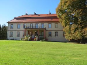 una casa grande con un gran césped delante de ella en Schloss Lohm, en Lohm