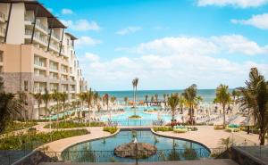 an aerial view of a resort with a pool and the ocean at Dreams Natura Resort & Spa - All Inclusive in Cancún