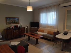 a living room with a couch and a table at 3 STEPS in Alexandroupoli