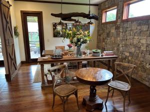 a dining room with a wooden table with chairs and flowers at The Dogwood Inn in Blue Ridge