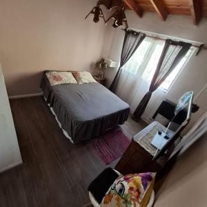 a bedroom with a bed and a desk and a chair at Alojamientos Copihue in Zapala